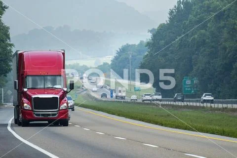 Big Red Eighteen Wheeler Cruising Down The Interstate Highway Hi Res