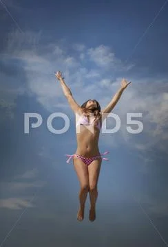 Photograph Caucasian Woman In Bikini Jumping For Joy 65133222