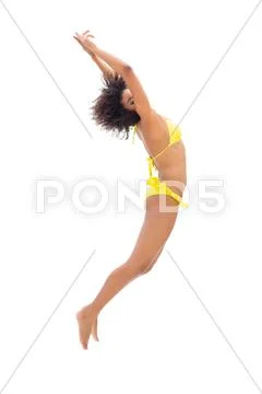 Fit Girl In Yellow Bikini Jumping And Stretching Stock Photo