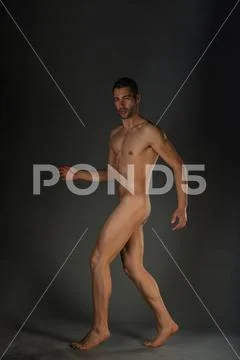 Full Length Portrait Of An Attractive Naked Man Posing In Motion For