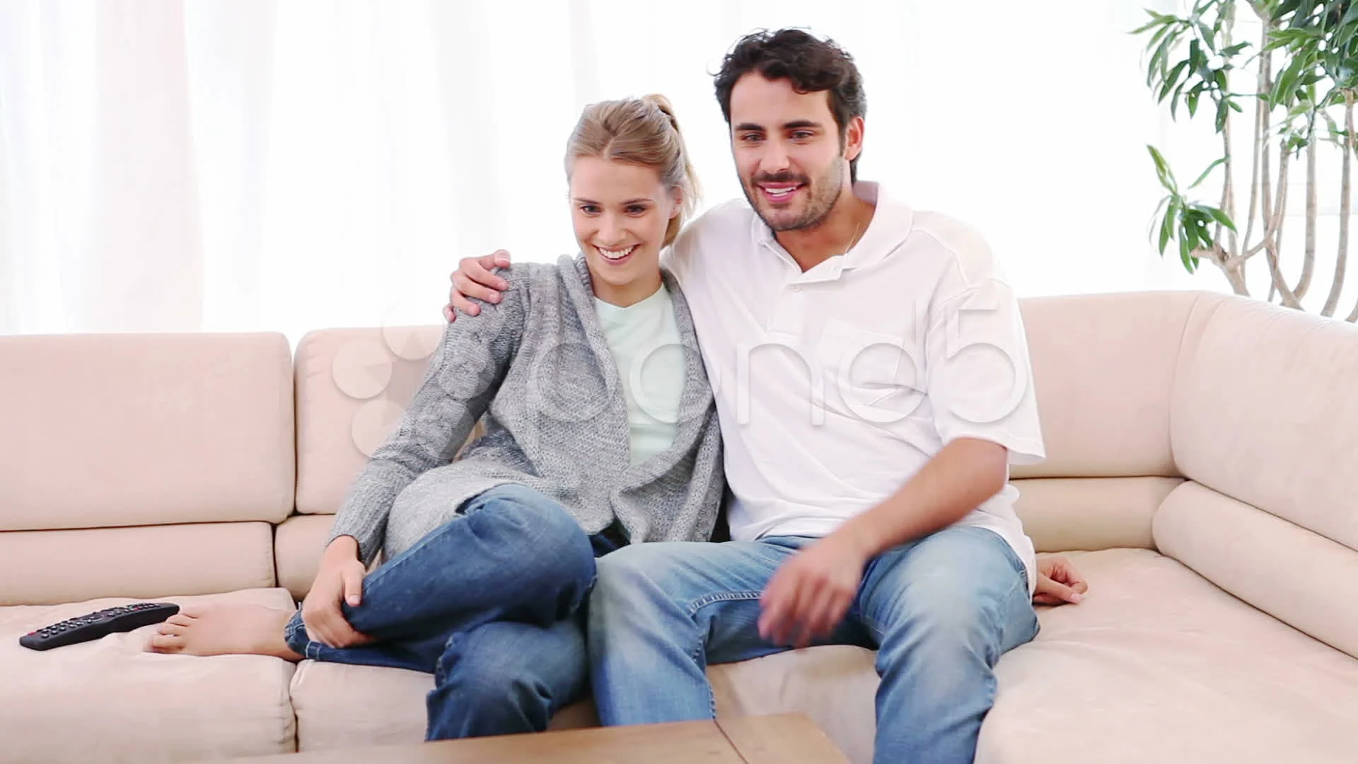 smiling-couple-sitting-couch-while-footage-010843617_prevstill.jpeg