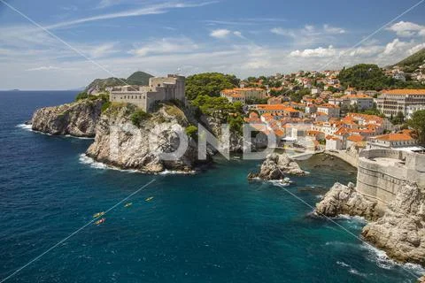 Surf on the cliffs of the city wall of Dubrovnik, Croatia with kayak boats