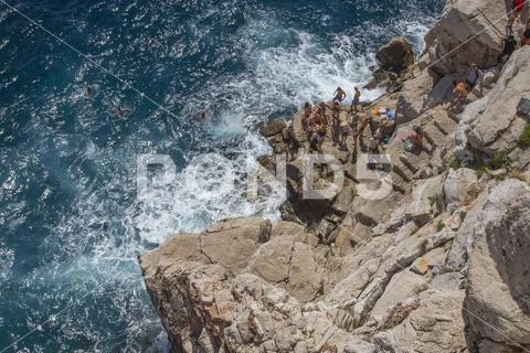 Tourists and swimmers on the cliffs of Dubrovnik, Croatia