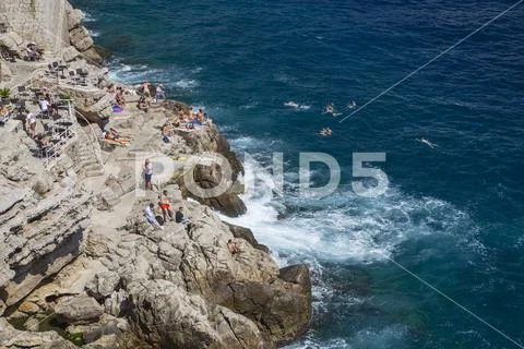 Tourists and swimmers on the cliffs of Dubrovnik, Croatia