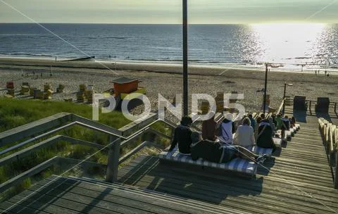 Sunset with stairs and relaxing tourists on the beach on Sylt