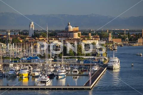 Suburb of Venice, Italy with harbor and Alps