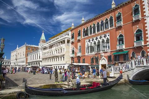 Tourists crowd at the quay and gondolas in Venice, Italy