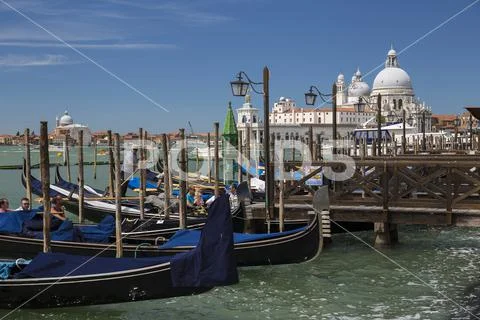 Gondolas with tourists in Venice with Basilica di Santa Maria della Salute Italy