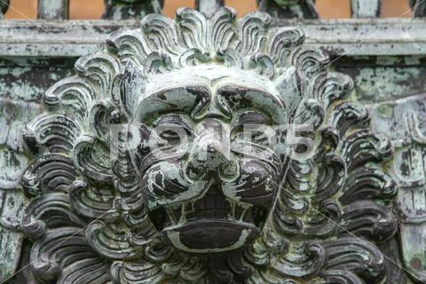 Forged lion head on the iron gate