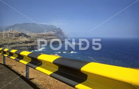 Madeira cliff with wind turbines and guard rail