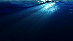 Underwater scene with sunrays shining through the water's surface. (Looping, Hig