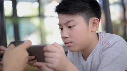  00:01 | 00:10 1×  Asian boy play game from smartphone. Stock Footage 87674537