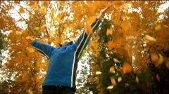 boy throws leaves up into air dolly shot 50% slowmo