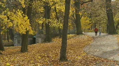 senior couple walking through park in autumn