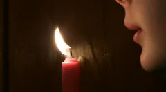 girl extinguishes a burning candle.