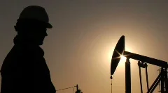 Oil worker wiping brow