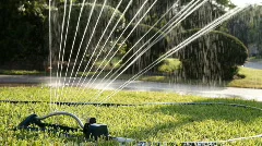 sprinkler watering a suburban lawn