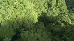 Aerial over a Mountain Range covered in Rain Forest revealing river & Waterfall