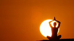 woman making yoga at sunset huge sun