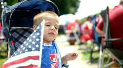 Young Boy in Stroller waving american flag