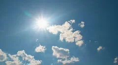 White clouds flying on blue sky with sun rays