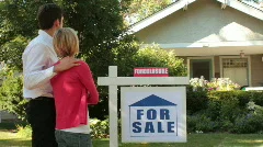 Couple standing in front of their foreclosed home
