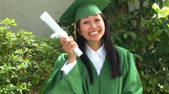 Young Asian woman in graduation gown with boyfriend outside