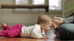 Mother helping baby stand