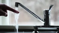 Drinking water from kitchen tap.