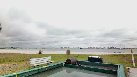 0023A large rusted lawn roller rests in a shallow water-filled pit of an unused 库存影片 332723420