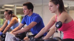 People in Gym Exercising on Stationary Bikes