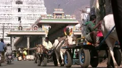 Cow carts and other traffic in front of a Hindu temple