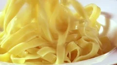 Putting ribbon pasta and tomato sauce on a plate