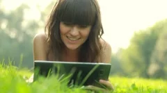 Young happy woman with tablet computer on meadow HD