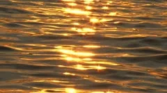 The reflection of the setting sun on the water surface.