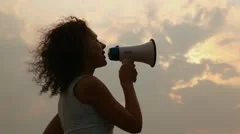 woman stands and tells something in megaphone