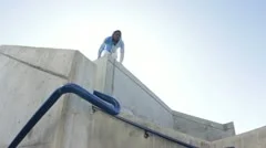 Man parkour jumps off stairs towards camera
