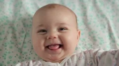 Cute baby lies on back and smiling (closeup)