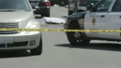 An out of focus dead body with crime scene tape in the foreground