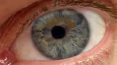 Extreme close up of eye twitching with iris contracting and pupil detail