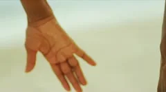 Close up of diverse female hands holding on beach  