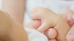 Parent holding newborns hand