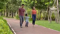 Young happy Asian family walking in the park together