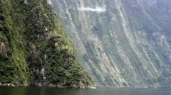 Boat tracking shot of Milford Sound's amazingly high and steep mountains