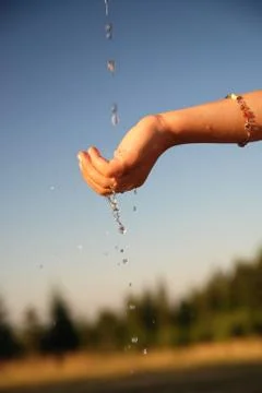 Clear water falling on children hands