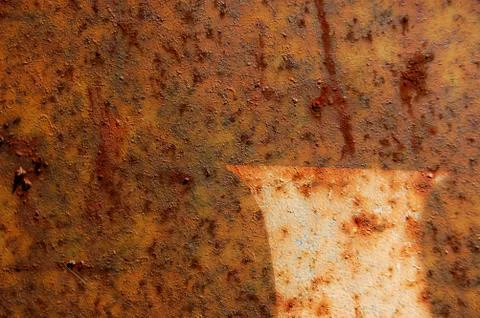 Type stencil detail on rusted metal surface. Abstract background