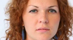 face of red-haired woman in blue drops close up