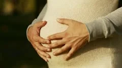 hands stroking pregnant belly
