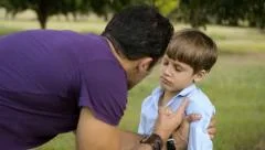Parenthood and children education, angry man scolding boy in park