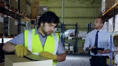 Worker in a factory is approached by his manager